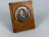 an old photo of a woman in a black dress in a wooden frame