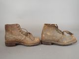 an old pair of brown boots with laces on them on a gray surface