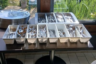 Plusieurs plateaux d'argenterie sont posés sur une table devant une fenêtre
