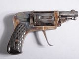 un petit pistolet posé sur une surface blanche