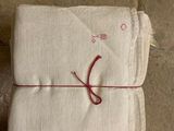 une pile de serviettes blanches entourées d'un fil rouge