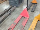 several forklifts and pallets are lined up in a warehouse