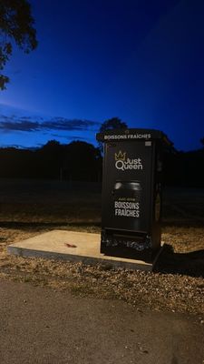 a black trash can sitting on the side of the road