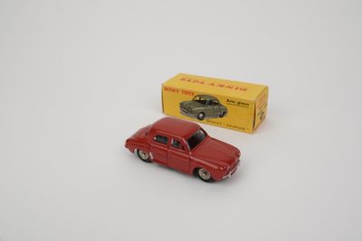 une vieille petite voiture rouge posée à côté d'une boîte jaune sur une surface blanche