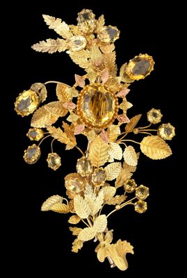 broche en forme de fleur plaquée or, ornée de cristaux et de feuilles sur fond noir