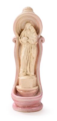 une statue représentant une femme tenant un bébé dans ses bras, posée sur un socle