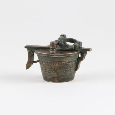 un vieux pot en bronze muni d'une poignée et d'une autre poignée