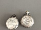 une paire de montres de poche anciennes en argent sur fond gris
