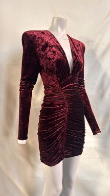the mannequin is wearing a red velvet dress with long sleeves