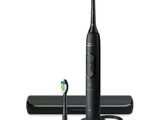 une photo d'une brosse à dents électrique noire posée à côté d'un chargeur