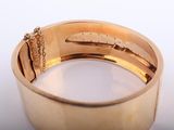 an image of a close up of a gold bracelet on a white surface