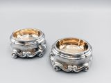 pair of silverplated bowls with handles and handles on a table