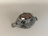 an old silver metal object with a tag on top of it