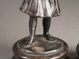 a statue of a girl holding a bird on top of a pedestal
