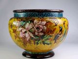 un grand vase jaune orné de fleurs peintes