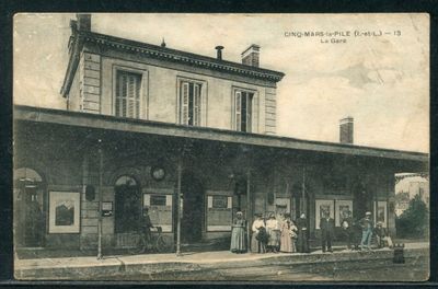 une photo en noir et blanc montrant des personnes debout à l'extérieur d'une gare