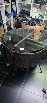 une table et des chaises en verre dans une pièce où se trouve une étagère remplie de chaussures