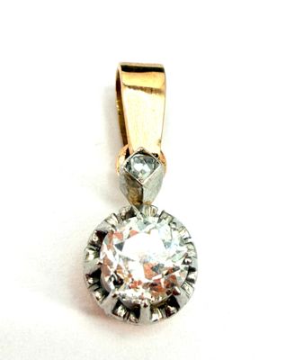 une photo d'un pendentif en diamant posé sur une surface blanche