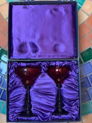 deux verres à vin rouge dans une boîte violette, posés sur un sol carrelé