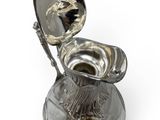 a silver toilet with a silver lid and a spoon in it