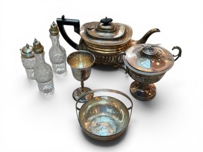 a silver tea set with a glass and a bottle