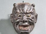 un masque accroché au mur d'une pièce sur fond bleu clair