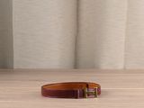 brown leather belt with gold buckle on wooden table in front of curtain