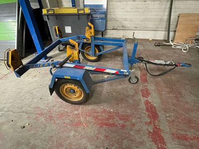 a small trailer with a fork attached to it in a garage