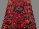 a red and black rug with a medallion design on it