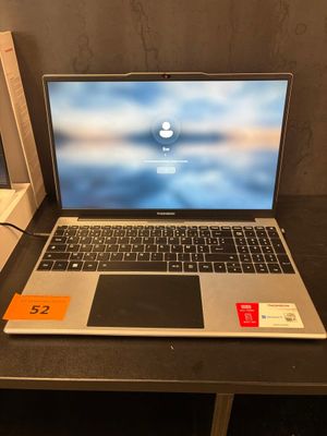 un ordinateur portable posé sur un bureau, avec son étiquette de prix
