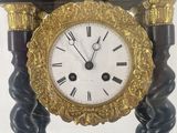a black and gold clock sitting on a stand