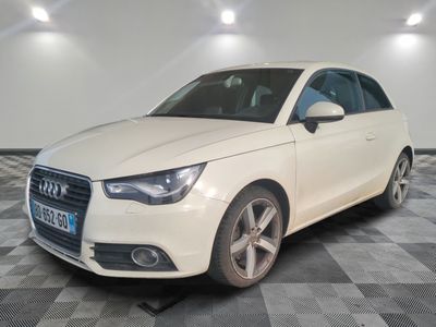 L'Audi blanche est garée sur un sol à damier dans un garage.
