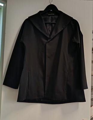 jacket hanging on a wall in a room with a bed and a window