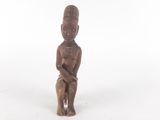 une vieille statue en bois représentant un homme tenant un bébé dans ses bras