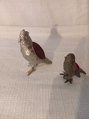 deux oiseaux qui sont posés l'un à côté de l'autre sur un canapé