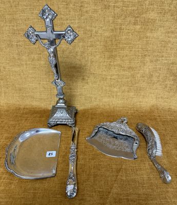 une assiette en argent ornée d'une croix, à côté d'un couteau et d'une cuillère