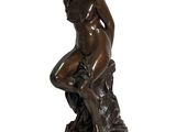 statue en bronze représentant une femme assise sur un rocher, les mains posées sur les genoux