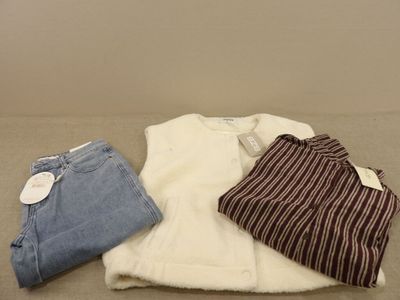 three pairs of clothes are laid out on a table
