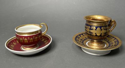 two cups and saucers are sitting side by side on a table