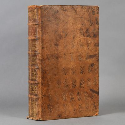 an old book sitting on top of a table next to a gray background