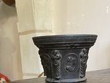 un pot noir posé sur une table en bois