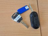 une clé de voiture et une télécommande posées sur une table