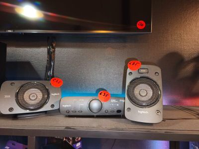 two speakers that are sitting on a shelf in front of a tv