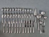 un grand nombre de cuillères et de fourchettes disposées sur la table