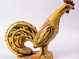 une figurine représentant un coq sur fond blanc