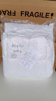 un sac de serviettes blanches posé sur une table blanche