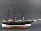 une maquette de bateau posée sur un socle en bois