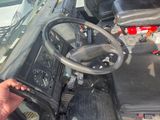 someone is holding a remote control in their hand while driving a tractor