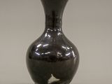 a black vase that is sitting on a table