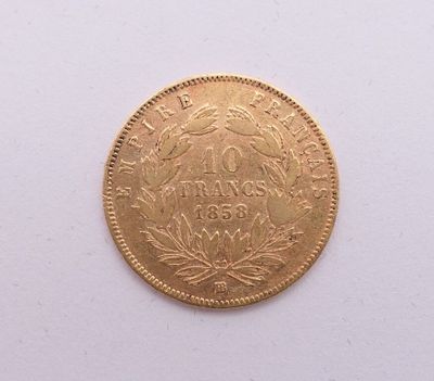 gros plan d'une pièce d'or sur une surface blanche